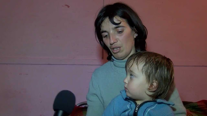Социално слаба самотна майка върви пеш в преспите с малкото си дете.