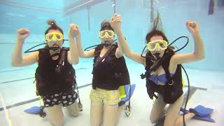 Group Of Women Learn To Scuba Dive In Pool