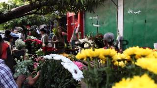 People buy and sell flowers at a street market on Februar...