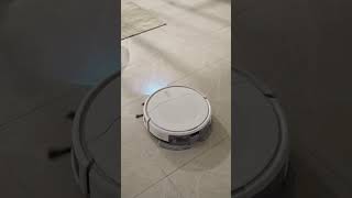 Modern white 2‑in‑1 robot vacuum and mop working on shiny tiled floor, bright minimalist living