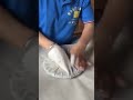 the stage of wrapping a circular shaped food using paper neatly and properly