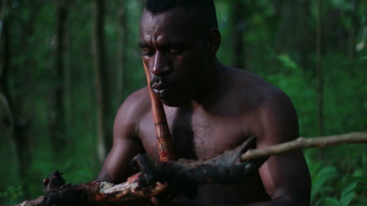 video player Tribal man primitively survives in the jungle: eats grilled Giant Lizard with no flavor