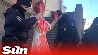 Russian covers herself in fake blood to protest war before police remove her