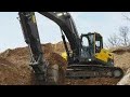 Escavadeira Hidráulica Jhon Deere 350G carregando caminhão