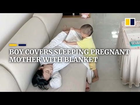 Boy covers pregnant mother with blanket after she falls asleep on sofa