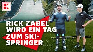 Rick Zabel jumps from the ski jump. Coach Philipp Raimund helps him out | Kaufland