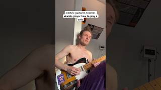 Electric guitarist teaches ukulele player how to play a solo