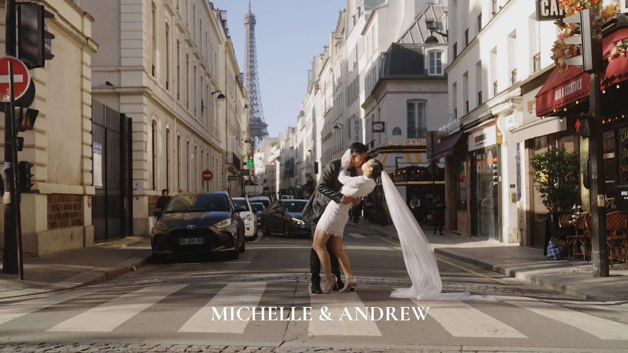 Bride and groom kiss in a Paris street with the Eiffel Tower behind them in soft daylight