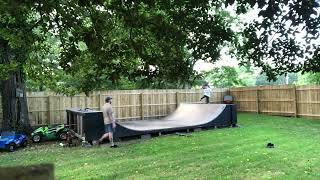 Boy drops into half pipe on his stomach with skateboard the falls forwards into scorpion position