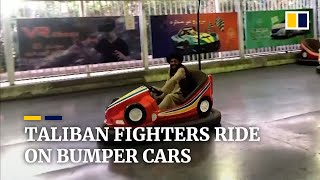 Taliban fighters take a ride on bumper cars at amusement park in Kabul