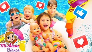 Le bambole e i bambini che giocano in piscina. Giochi per i bambini piccoli con la bambina Bianca