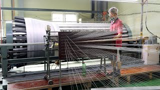 Процесс массового производства огромного ковра, состоящего примерно из 9600 нитей.
