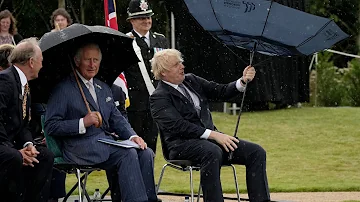 Boris Johnson struggles with umbrella at police memorial unveiling