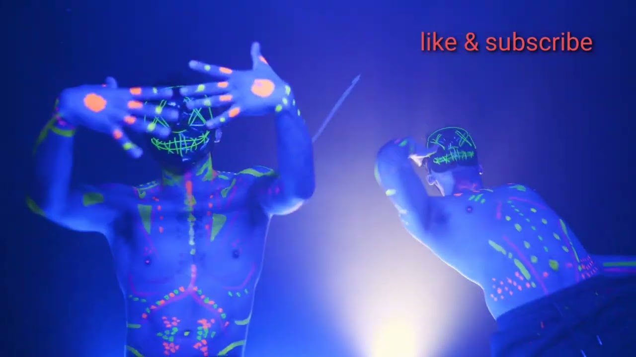 man dancing in party light with Halloween Masks & fluorescent paint on their bodies.