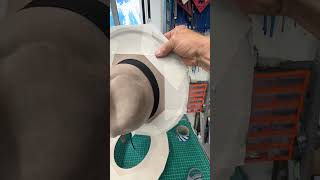 Tip for holding down large brim hats for engraving