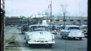 U.S.A. cars travelling to industrial site or factory.  Archive film 93147