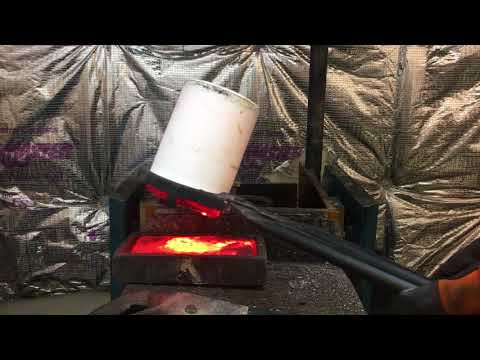 Pouring molten gold from a crucible into a graphite ingot mold