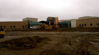 Deere 770D and Cat 615C grading parking lot