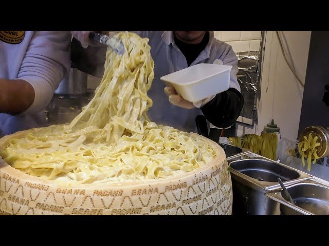 Hand Made Pasta Fettuccine Drowned in a Cheese Wheel. Italian Street Food in London Camden Town