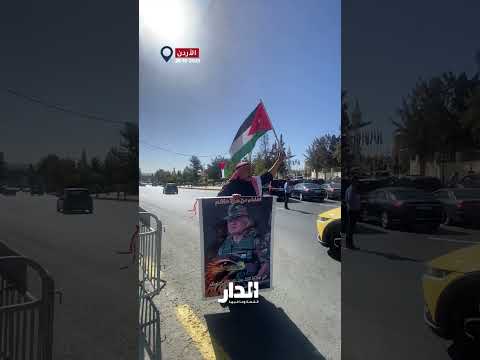 مواطن أمام مجلس الأمة يرفع صورة جلالة الملك قبيل خطاب العرش