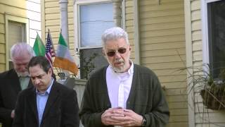 Father Begin prays at boxing champ Johnny Kilbane's house