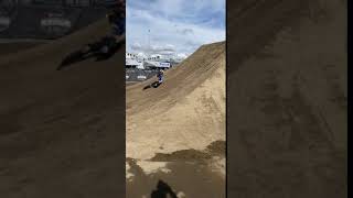 BMX rider goes up dirt ramp but bike misses landing and rider flips frontwards