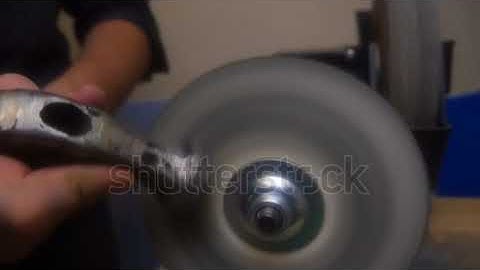 Man sharpens a working tool on a machine close up