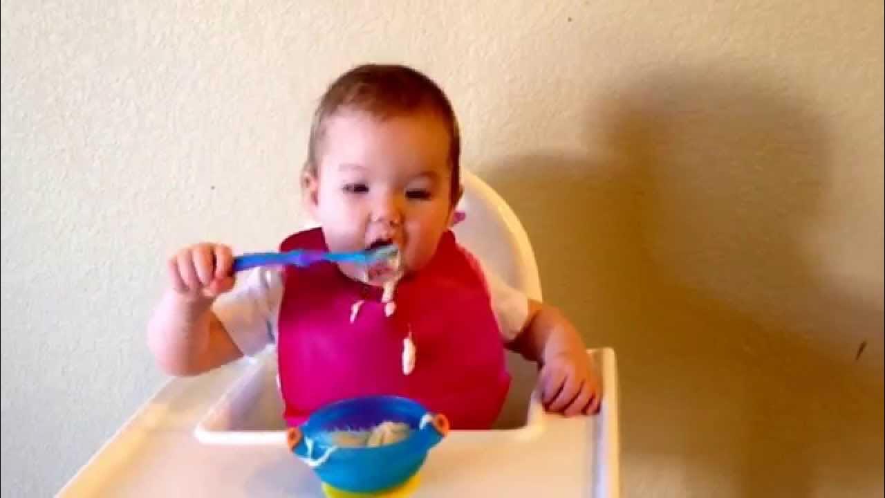 Baby Avy self feeding with spoon and bowl at 11 months (baby led