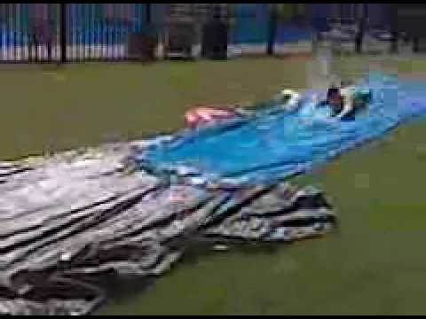 This is a slip and slide, flip cup relay race. 