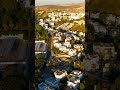 Vertical video. Bodrum, Turkey. Aerial drone view of white flat-roofed houses terraced on hillsid...