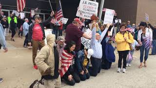 Protestors kneel outside the BoS Center In Springfield in support of reopening Illinois.