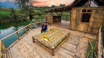 Build a bamboo house with a grass roof on a dangerous cliff next to a big river with house for fish