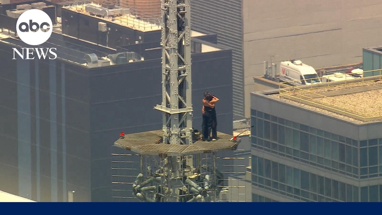 Masked climbers get engaged on the spire of the Empire State Building