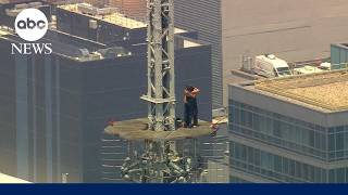 Masked climbers get engaged on the spire of the Empire State Building