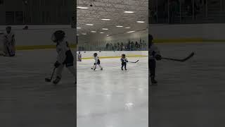 Boy playing hockey in ice rink accidentally skates into wall