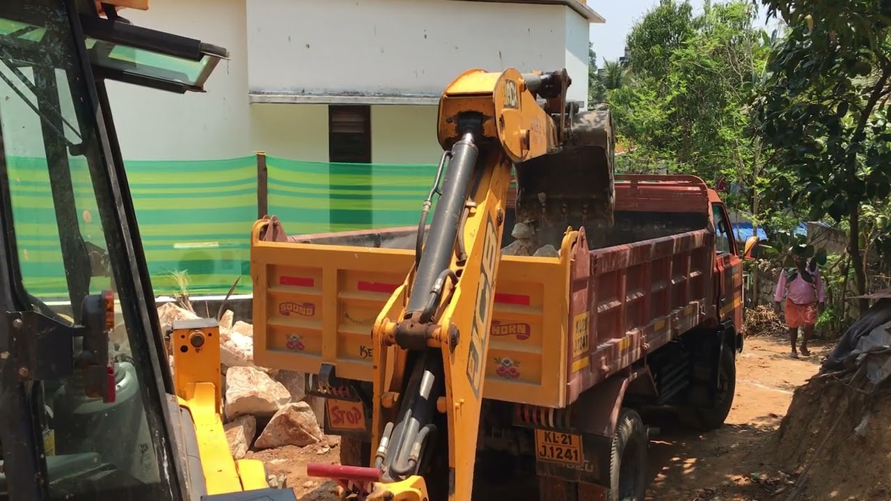 Jcb 3dx loading rock pieces into truck