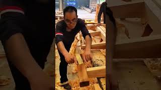 smoothing the surface of large wooden beams with traditional hand plane tool for house construction
