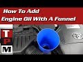 Adding oil to your car's engine with a funnel