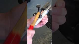 Planishing a seam on a sterling silver tube.