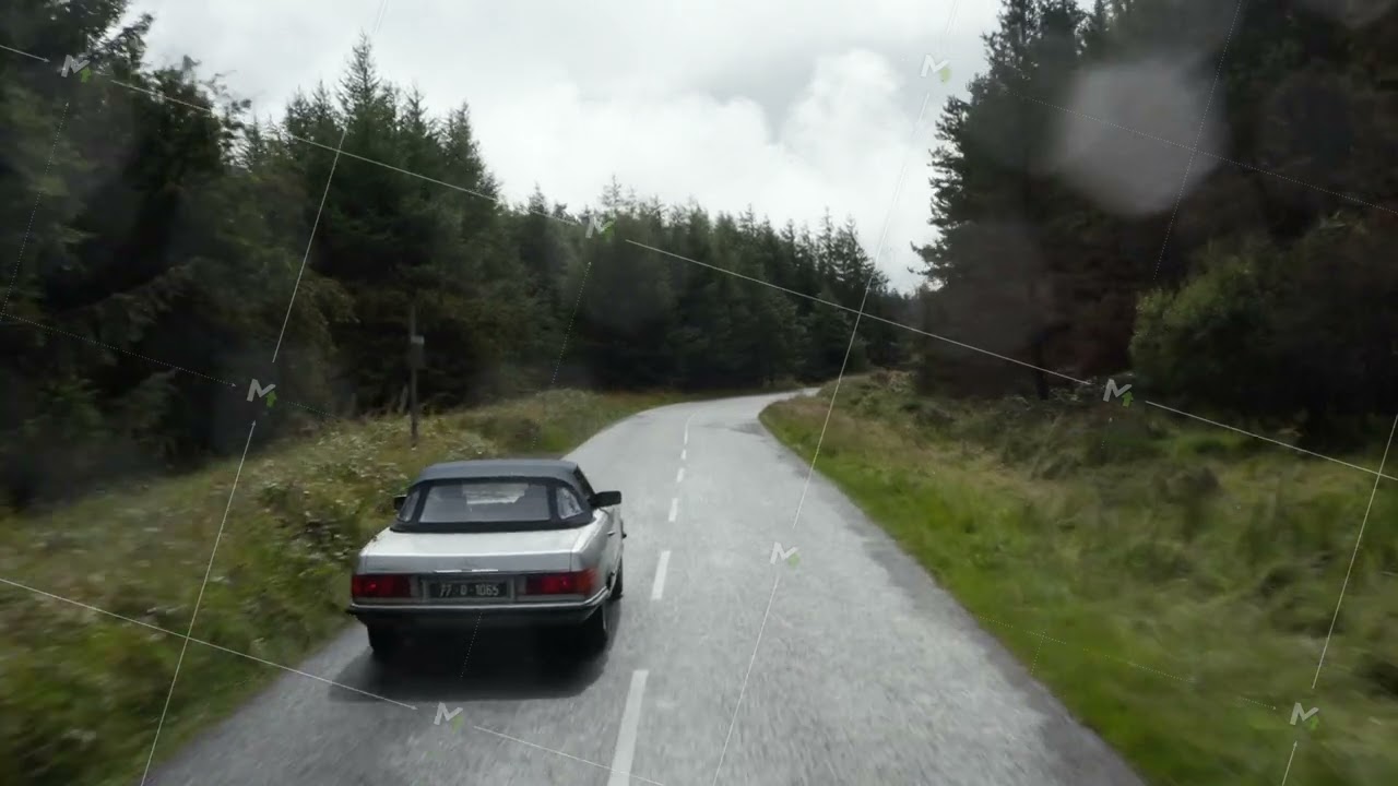 Fly over silver convertible car driving on road in forest on cloudy day. Starting to rain, raindrops