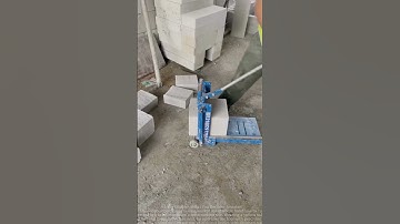 Skilled Worker Uses Hand Saw to Cut Cement Bricks Efficiently at Construction Site