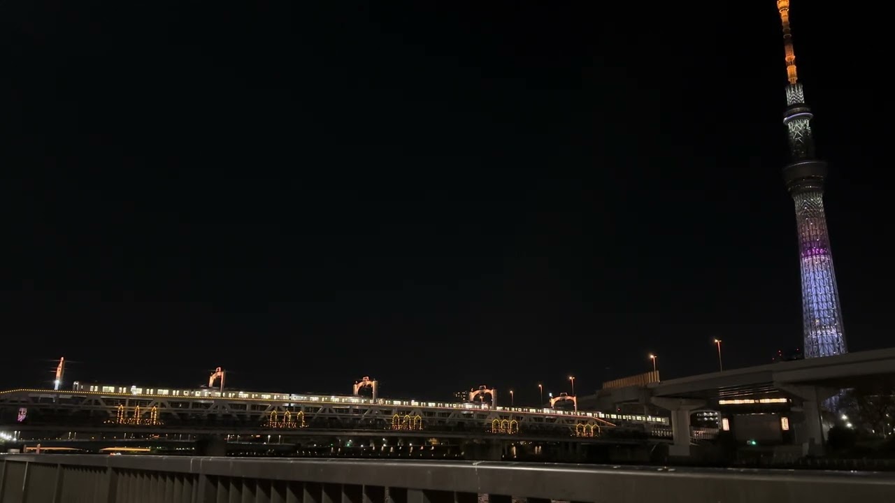 Tobu Skytree Line train passing slowly over Sumida River bridge by night [4K]