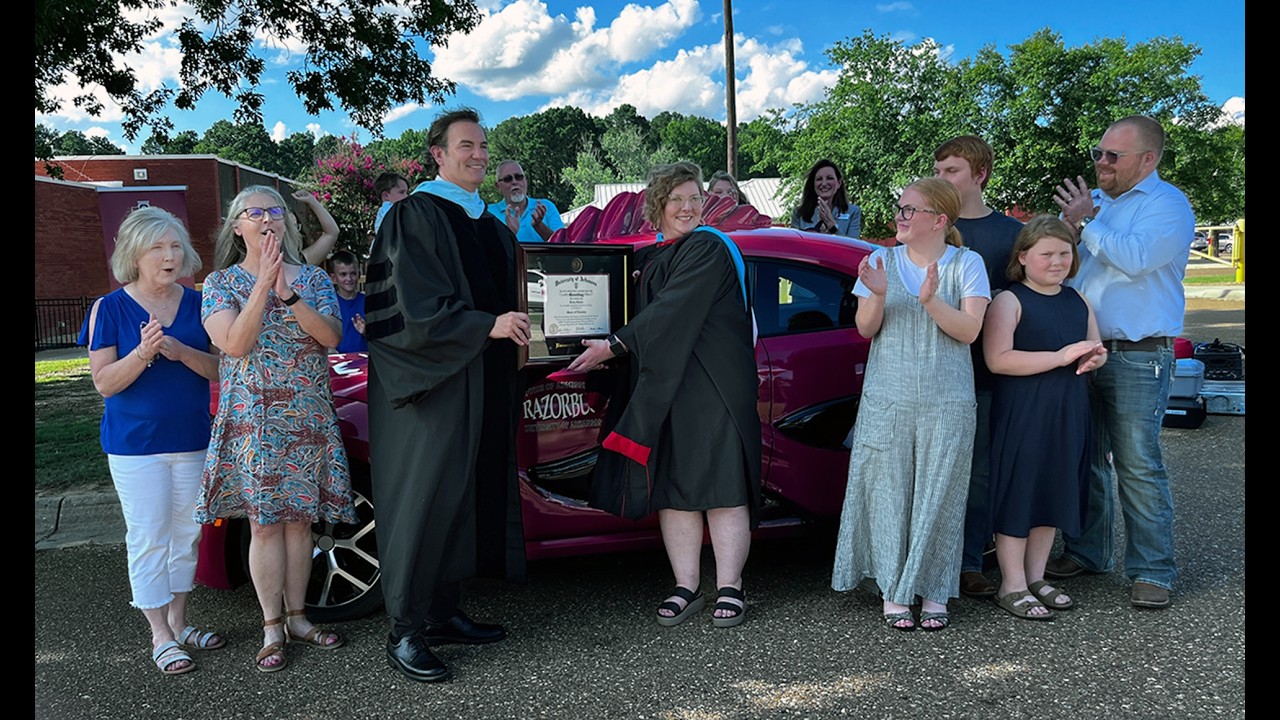 John Bacon presents a framed diploma to Kirby Gibson on June 11 during the Razorbug Diploma Tour at Hermitage Elementary School