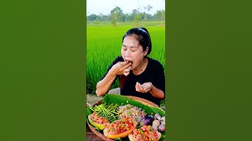 A beautiful Khmer woman an manwith fair skin and a warm smile sits in her traditional open air kitch
