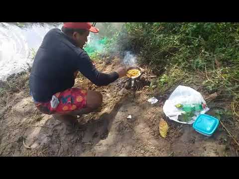 Pegando e fritando camarão na beira do rio