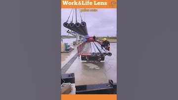 Efficient gantry crane loads concrete poles onto barge safely and quickly.