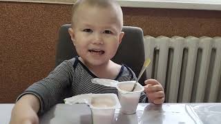 малыш кушает йогурт нежный со вкусом клубники и банана