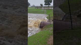 flood waters washing away road. water higher then the pipes
