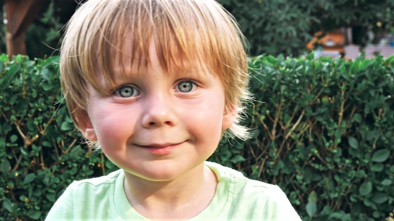 Video preview image of A picture of a young boy sitting in front of a shrub; click to visit the ParentSquare post with the video