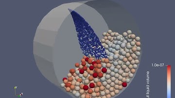 Wetting of particles by a flat spray nozzle in a rotating drum